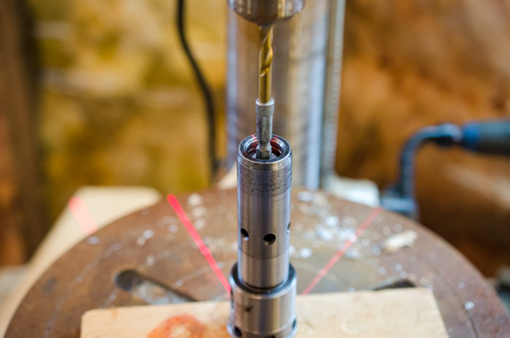 Photo showing using a drill press as a press to aid removal and installation of a snap ring into the coupler of a John Deere 1640/2040 Breakaway Coupler.